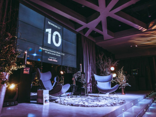 Special Event by Nespresso Stage setup with large screen displaying the number 10 for Nespresso Gourmet Weeks 2018, flanked by frosty decor and modern chairs on a circular rug.