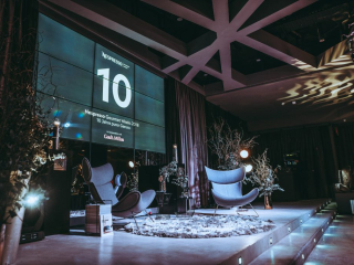 Special Event by Nespresso Stage area with oversized digital countdown showing '10' for Nespresso Gourmet Weeks 2018, decorative seating and winter-themed trees on a lit platform backstage setup.