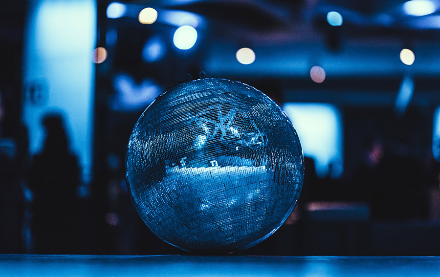 Blue disco ball reflecting blue lights in a dim party venue on a table surface